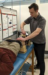 A man performs a treatment on a patients legs