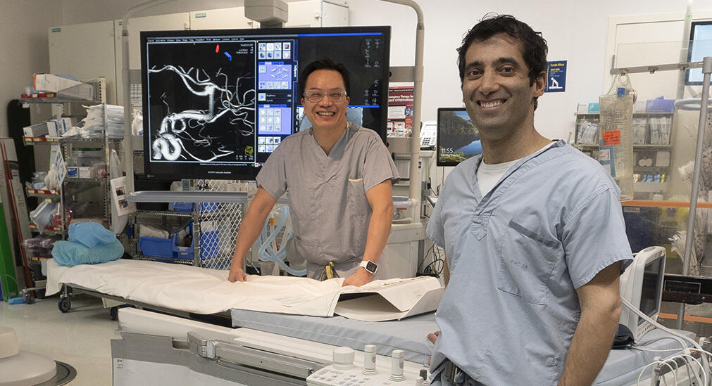 A group of surgeons stand in an operating theatre