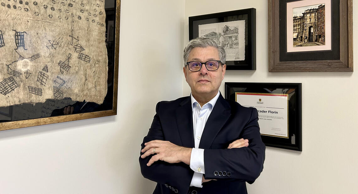 A man stands in front of framed photos